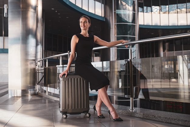 Mulher de negócios elegante com bagagem no aeroporto