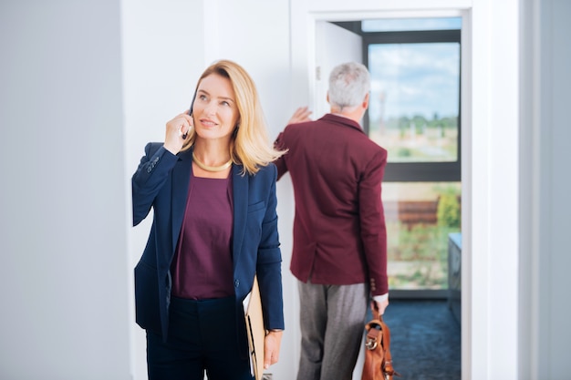 Mulher de negócios elegante. Mulher de negócios bonita e elegante recebendo uma ligação importante de seu parceiro enquanto estava no centro de negócios