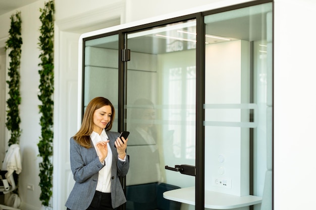 Mulher de negócios elegante verificando seu relógio inteligente em um ambiente de escritório moderno