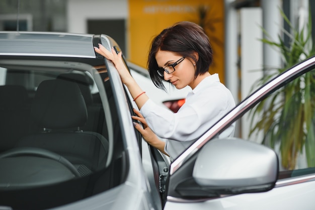 Foto mulher de negócios em uma concessionária de automóveis. conceito de mulher de sucesso