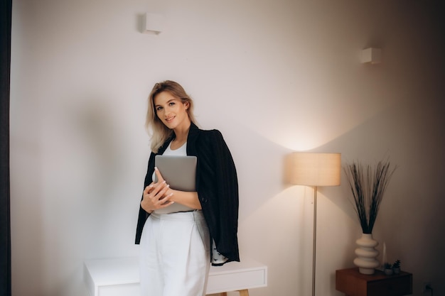 mulher de negócios em uma jaqueta preta com um laptop no escritório