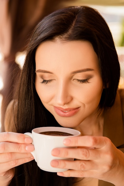 Mulher de negócios encantadora sentada em um café