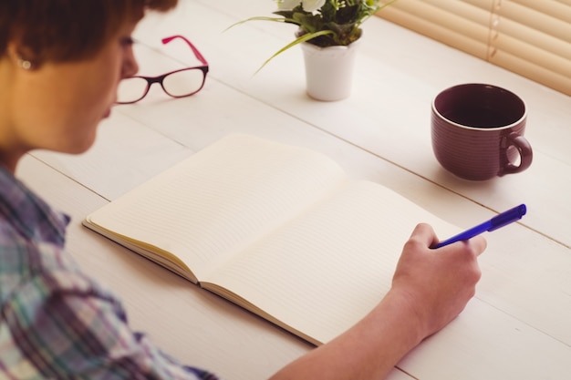 Mulher de negócios escrevendo notas no livro