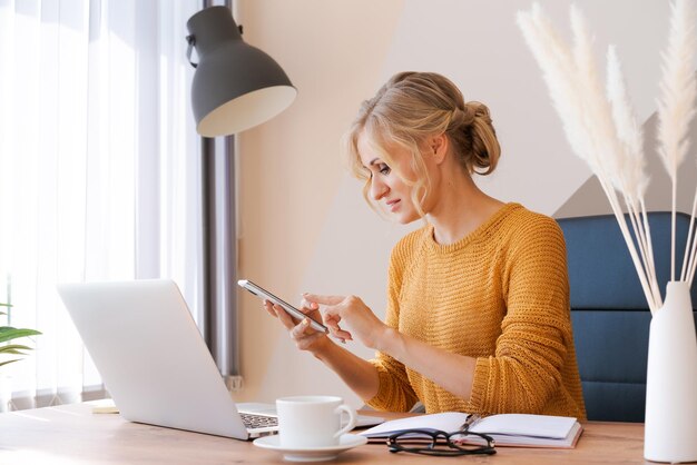 Mulher de negócios europeia atraente está no telefone e tomando notas ao mesmo tempo