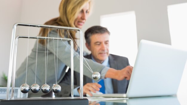 Mulher de negócios explicando algo no computador para um empresário concentrado