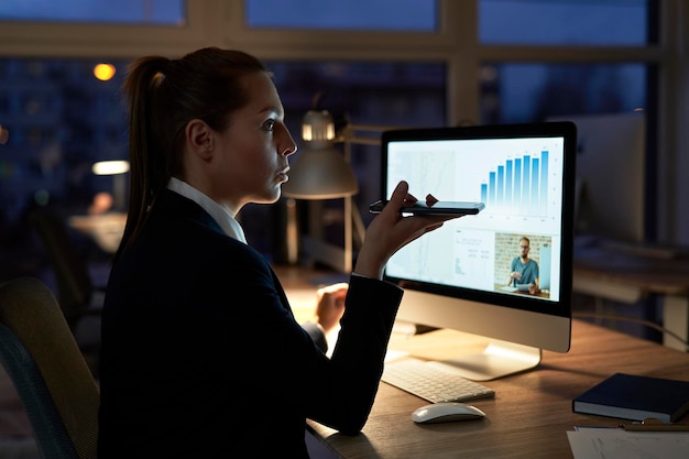 Foto mulher de negócios falando ao telefone enquanto trabalha no escritório à noite