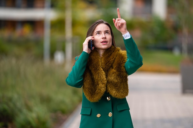 Mulher de negócios falando com clientes no celular no distrito comercial