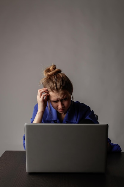 Foto mulher de negócios fazendo brainstorming enquanto usa laptop contra um fundo cinzento