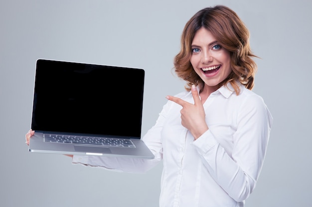 Mulher de negócios feliz apontando o dedo na tela do laptop