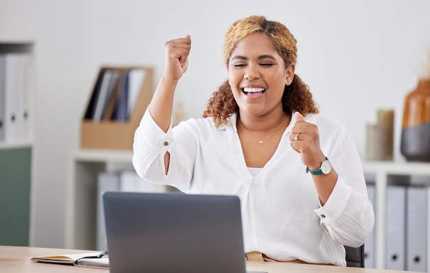 Mulher de negócios feliz com celebração e com laptop em sua mesa em um local de trabalho de escritório moderno Realização ou felicidade de sucesso ou alegre e comemorar sorriso de pessoa do sexo feminino para objetivo ou alvo