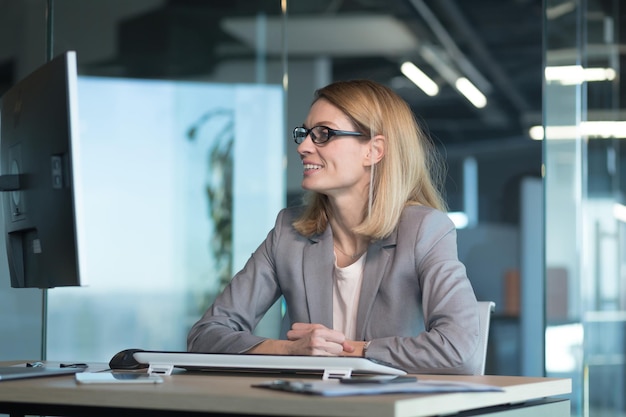 Mulher de negócios feliz e bem-sucedida que trabalha no escritório no computador se alegra com bons resultados empregado e chefe de sucesso