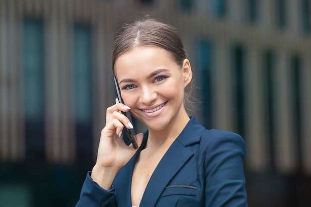 Mulher de negócios feliz e positiva falando no celular