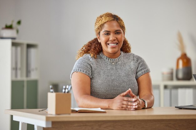 Mulher de negócios feliz e profissional confiante, pronta para o sucesso em sua mesa no escritório Jovem mulher sentada no trabalho sorrindo e se sentindo positiva sobre seus objetivos de carreira