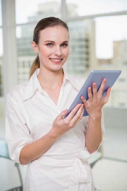 Mulher de negócios feliz que prende seu Tablet PC