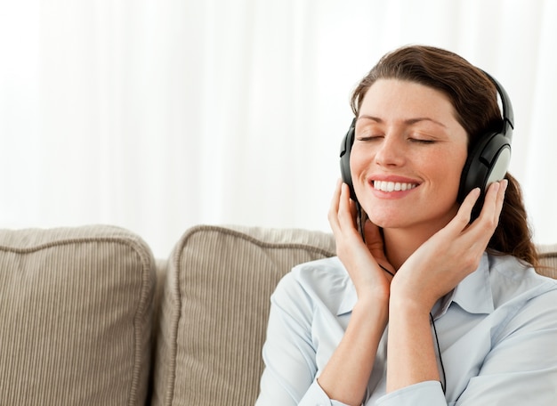 Mulher de negócios feliz relaxando com música na sala de estar