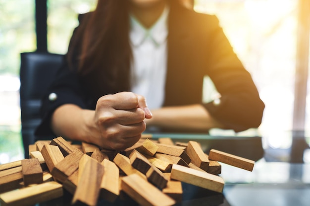 Mulher de negócios fica com raiva e destrói blocos de madeira do jogo Tumble Tower na mesa