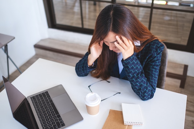 Mulher de negócios fica estressada enquanto tem um problema no trabalho no escritório