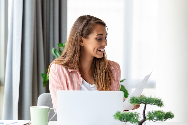 Mulher de negócios focada usando laptop em casa olhando para a tela conversando lendo ou escrevendo e-mail sentada no sofá aluna fazendo lição de casa trabalhando no projeto de pesquisa online