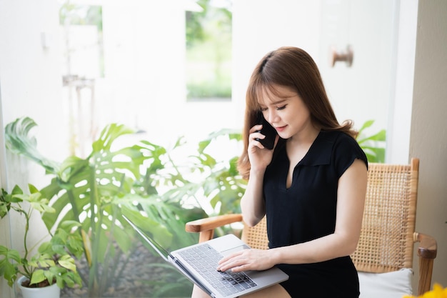 Mulher de negócios freelance ligando para smartphone móvel enquanto trabalha com laptop empresária celular para ligar para clientes ou fazer compras on-line conferência de conversação por telefone inteligente