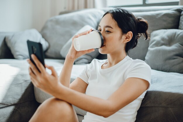 Mulher de negócios freelance trabalhando em casa pela manhã com laptop e copo de bebida quente, jovem mulher feliz, empresária, estilo de vida, tecnologia informática, trabalho online