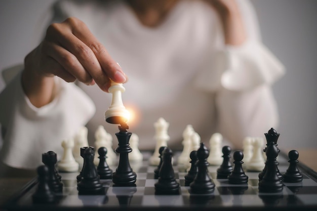 Mulher de negócios joga com jogo de xadrez. conceito de estratégia e tática de negócios. conceito de estratégia, gestão ou liderança
