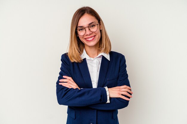 Mulher de negócios jovem caucasiana isolada na parede branca que se sente confiante, cruzando os braços com determinação.