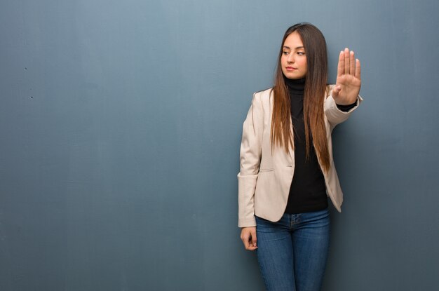 Mulher de negócios jovem colocando a mão na frente