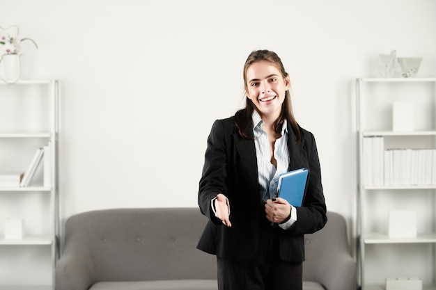 Mulher de negócios jovem dá boas-vindas ao relacionamento de entrevista de saudação de aperto de mão com parceiro de negócios