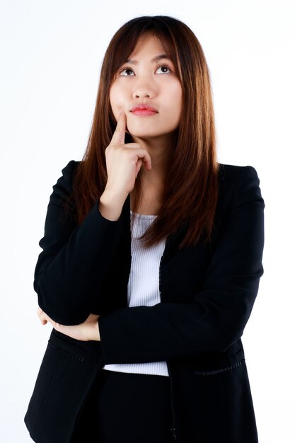 Mulher de negócios jovem e bonita em pose formal de terno preto em gesto de pensamento sobre fundo branco.