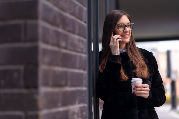 Mulher de negócios jovem falando ao telefone ao ar livre