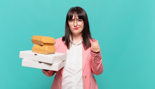 Mulher de negócios jovem fazendo capice ou gesto de dinheiro, dizendo para você pagar suas dívidas!