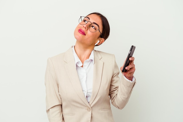 Mulher de negócios jovem segurando um telefone celular isolado no fundo branco