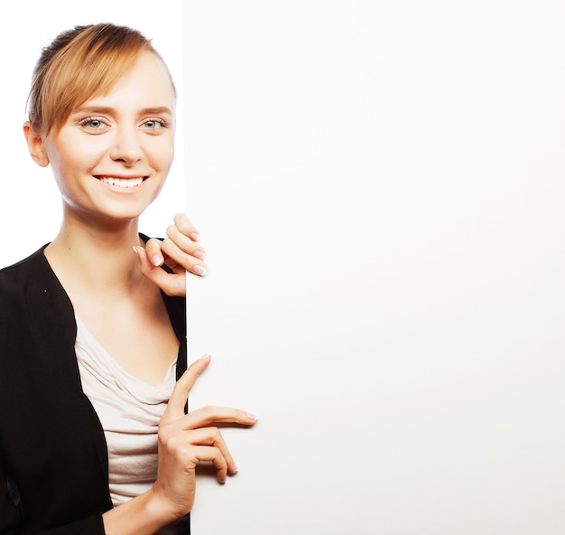 Mulher de negócios jovem sorridente feliz mostrando uma tabuleta em branco sobre fundo branco