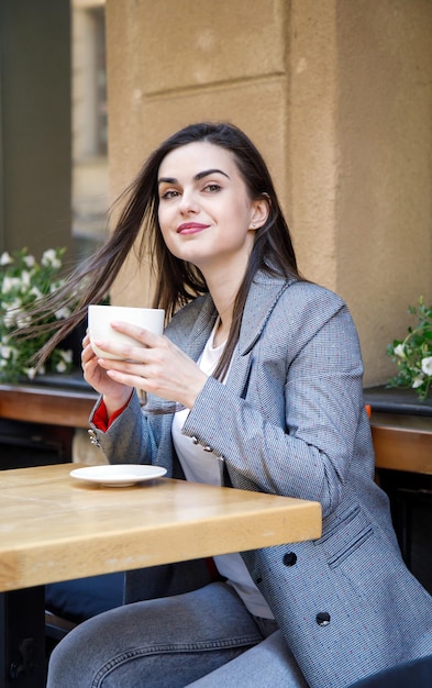 Mulher de negócios jovem tomando um café na cafeteria da rua