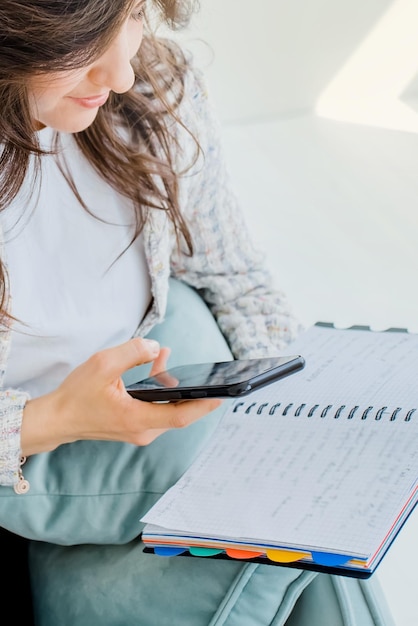 Foto mulher de negócios jovem trabalhando remotamente senta-se com um laptop e escreve notas