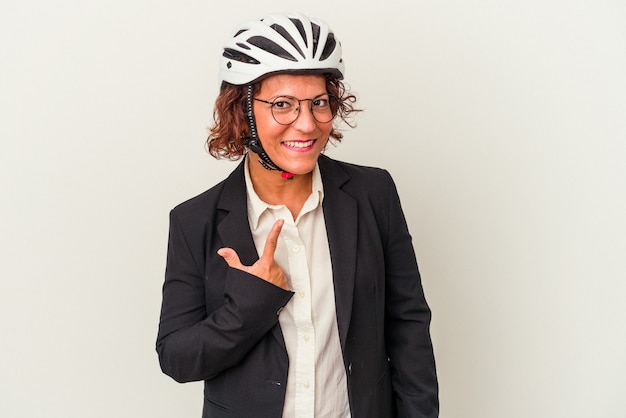 Mulher de negócios latinos de meia-idade usando um capacete de bicicleta isolado no fundo branco, apontando com o dedo para você como se estivesse convidando a se aproximar.