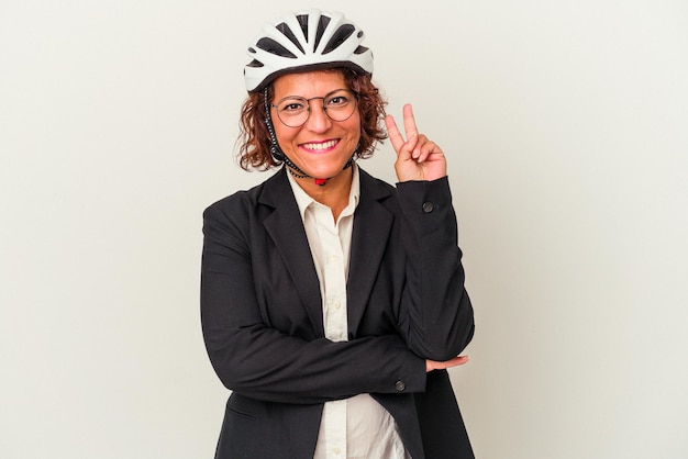 Mulher de negócios latinos de meia-idade usando um capacete de bicicleta isolado no fundo branco, mostrando o número dois com os dedos.