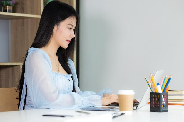 Mulher de negócios lendo gráficos financeiros gráficos informações de negócios com computador laptop Escritório de trabalho de mulher de negócios Relatório de dados financeiros de análise de trabalhador financeiro feminino