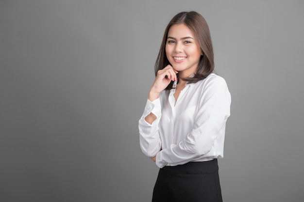 Mulher de negócios linda sorrindo em fundo cinza