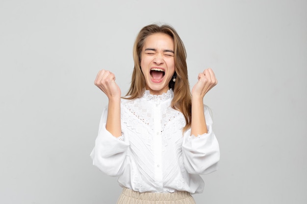 Mulher de negócios louca com raiva gritando e gritando louca mostrando raiva isolada em um fundo cinza branco Retrato de uma jovem muito emocional