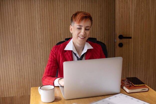 Mulher de negócios madura feliz empresária no escritório usando laptop no trabalho