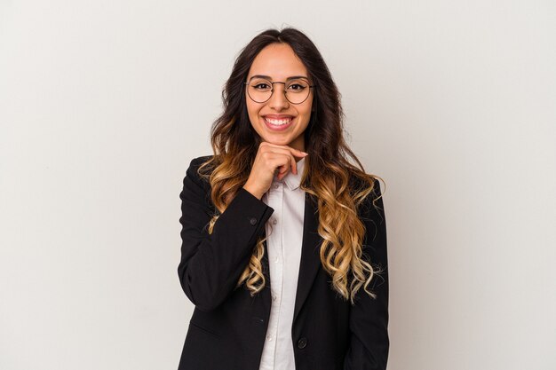 Mulher de negócios mexicanos jovem isolada na parede branca, sorrindo feliz e confiante, tocando o queixo com a mão.