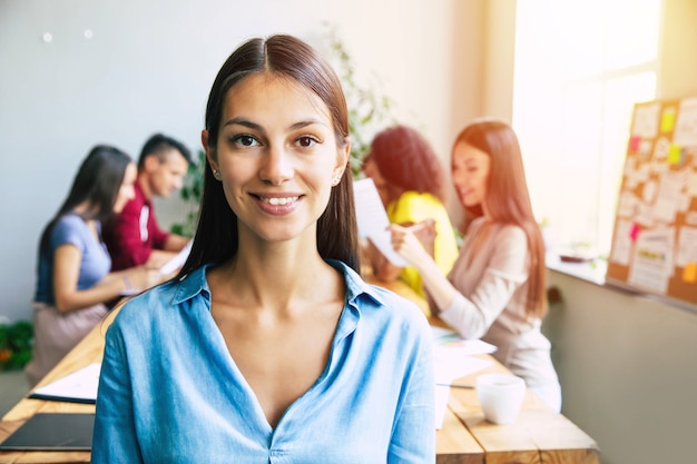 Mulher de negócios moderna confiante bonita em roupas casuais Olha para a câmera e sorrindo. Equipe moderna de start-up de negócios no escritório