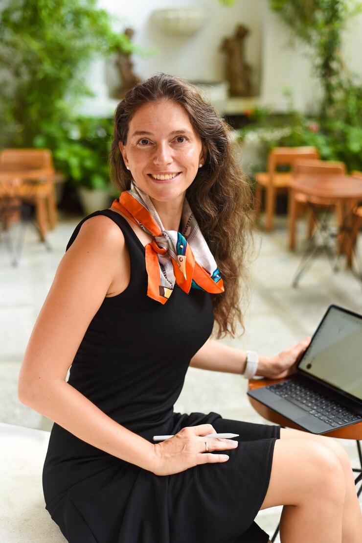 Foto mulher de negócios morena de 40 anos trabalhando com um tablet e olhando para a câmera