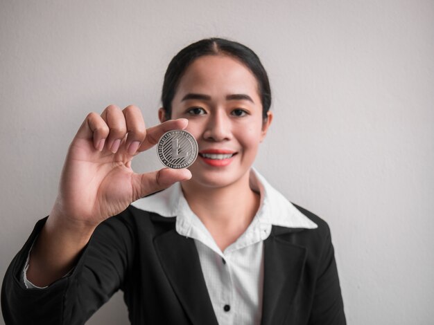 Mulher de negócios mostrando prata litecoin.
