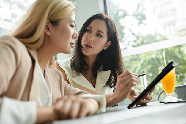 Mulher de Negócios Mostrando Relatório para o Colega