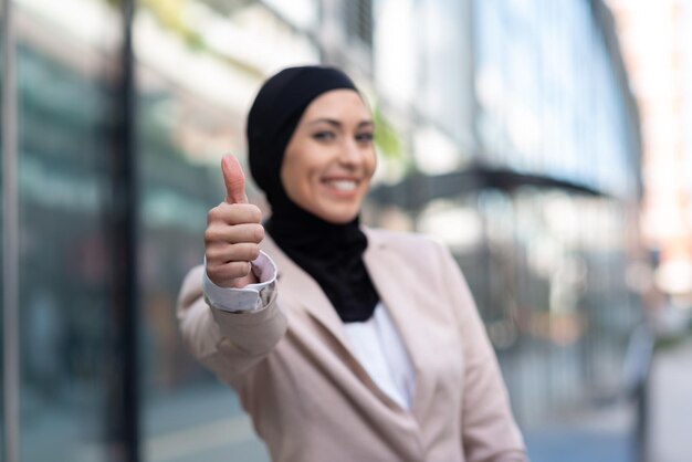 Mulher de negócios muçulmana feliz mostrando os polegares