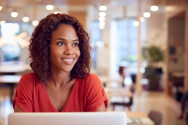 Mulher de negócios na mesa no espaço de trabalho de escritório moderno com laptop