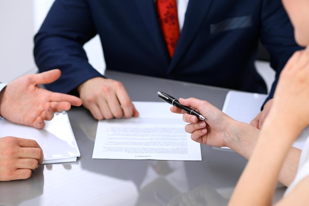 Mulher de negócios oferecendo caneta preta de empresário para assinar um contrato.