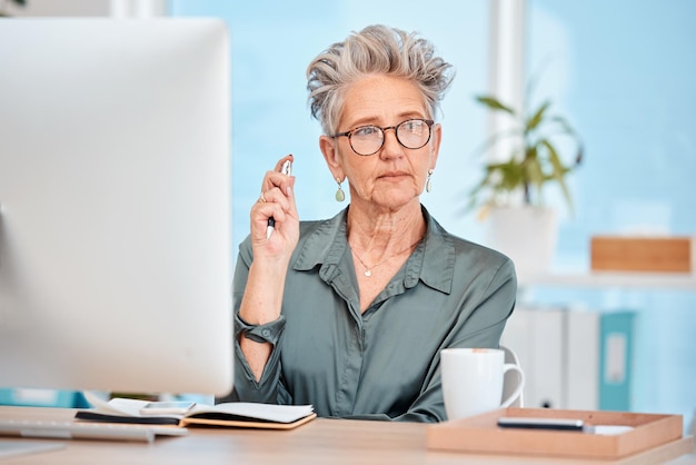 Mulher de negócios pensando e pensando em ideias para iniciar o projeto de marketing no escritório na mesa Planejando com uma funcionária sênior trabalhando com uma mentalidade de resolução de problemas ou estratégia no trabalho